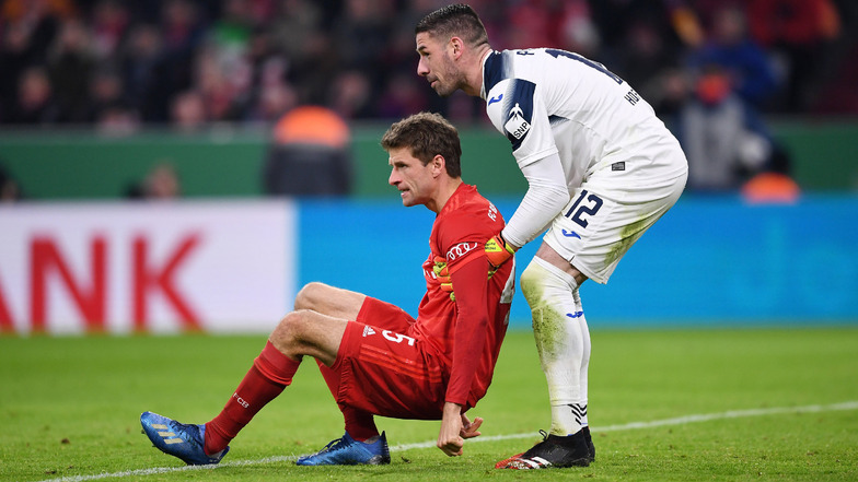 Wenn es sein muss, hilft er auch den Stars wieder auf die Beine: Hoffenheims Torwart Philipp Pentke (r.) greift Bayern Münches Thomas Müller unter die Arme.