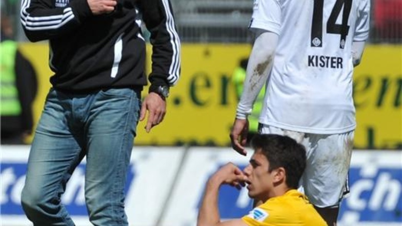 Aalens Trainer Ralph Hasenhüttl (l.) geht nach dem Spiel am auf dem Boden sitzenden Dresdens Anthony Losilla vorbei.