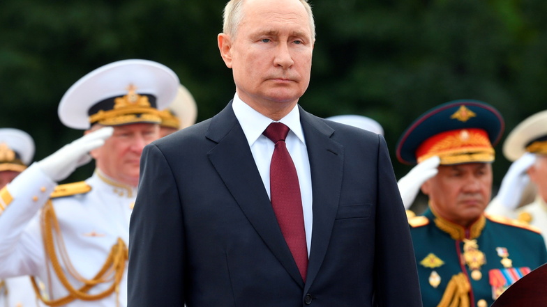 Wladimir Putin hält seine Rede, während Marine-Chef Admiral Nikolai Jewmenow (l.) und Verteidigungsminister Sergej Schoigu (r.) während der Parade zum Tag der Marine salutieren.