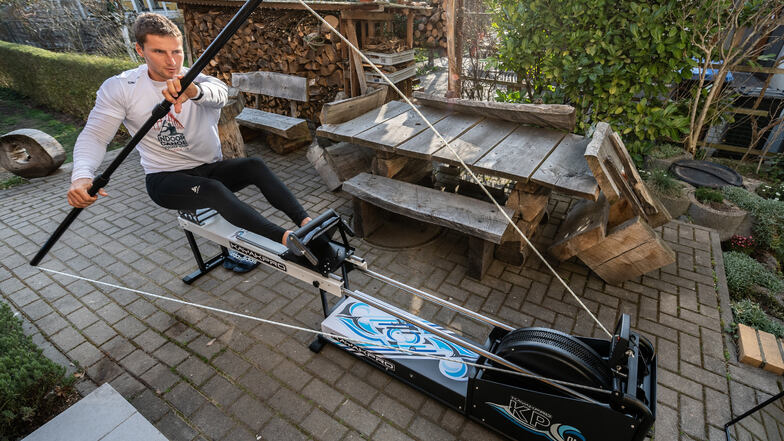 Dresdens Kanu-Olympiasieger Tom Liebscher trainiert in seinem Garten auf einem Paddelergometer. Nach der Olympia-Verschiebung auf kommendes Jahr hält er sich fit.