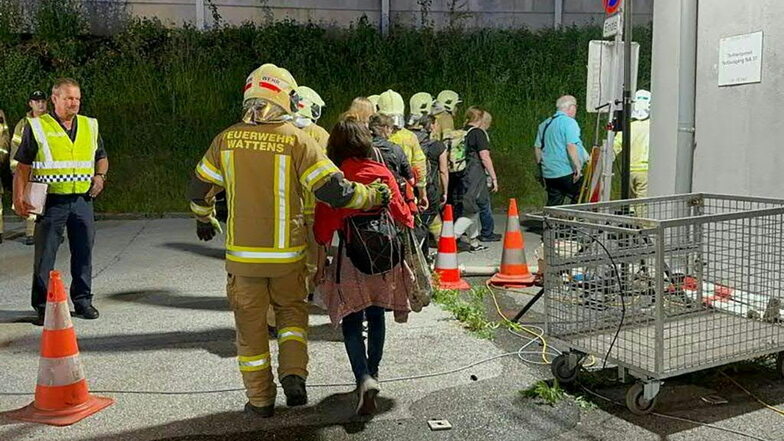 Rettungskräfte geleiten nach einem Brand Nachtzugpassagiere aus einem Bahntunnel in Tirol, in dem es gebrannt hat.