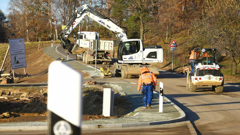 Mitarbeiter der Firma STL Bau räumen in Niederoderwitz die Baustelle.