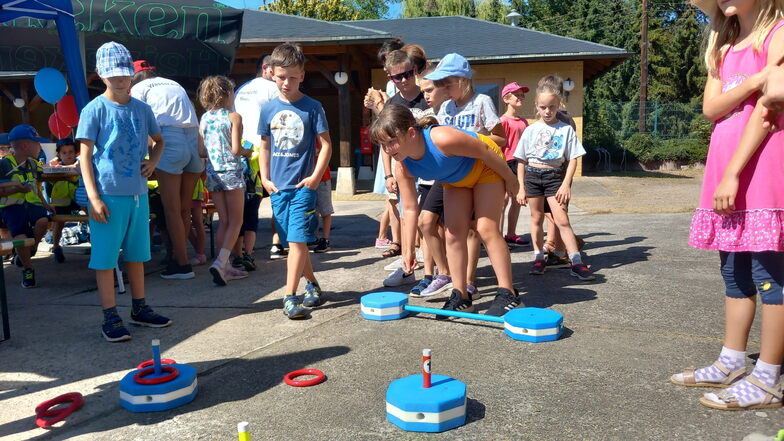 Kinder der Klasse 3a testen am Stand der Wasserwacht Riesa ihr Geschick beim Zielschießen mit Ringen.