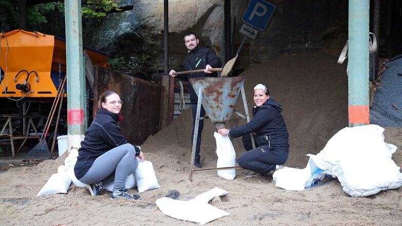 Kathy Heller, Marcus Stimpel und Laura Trümper, Mitarbeiter vom Restaurant "Zur Schlossbastei" in der Kirchstraße füllen Sandsäcke ab..