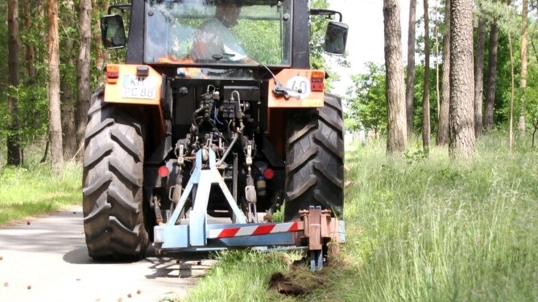 Dieser mit einem Reißhaken ausgestattete Traktor des Bernsdorfer Bauhofes war im Sommer 2014 auf mehreren Radwegen und Straßen in der Stadt und den Ortsteilen unterwegs, um die unter die betreffenden Wege gewachsenen Wurzelstränge zu durchtrennen.