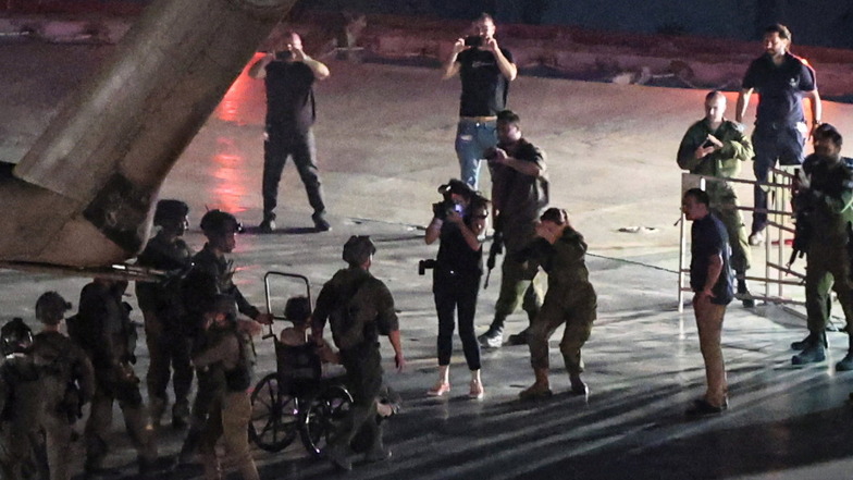 Eine der befreiten Geiseln in einem Rollstuhl rollt nach der Landung auf dem Dach des Ichilov-Krankenhauses aus einem israelischen Militärhubschrauber.