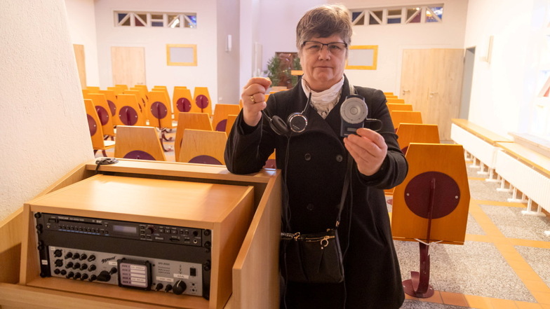 Ines Reimann zeigt die Hörgeräte in der Trauerhalle auf dem Waldfriedhof in Niesky. Fünf Geräte hat die Stadt angeschafft.