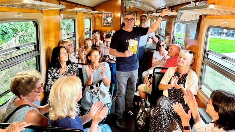 Autor Jaroslav Rudis (stehend mit Buch) fährt mit der Schmalspurbahn
von Zittau zum Bahnhof Bertsdorf zu seiner Lesung. 180 Fans begleiten ihn - der Schriftsteller ist begeistert von so viel Interesse.