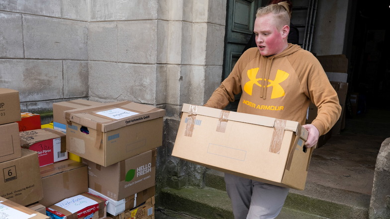 Linus Pohl gehört zu den vielen freiwilligen Helfern, die gepackte Kisten mit Spenden für den Transport aus der Unterkirche in Kunnerwitz tragen.