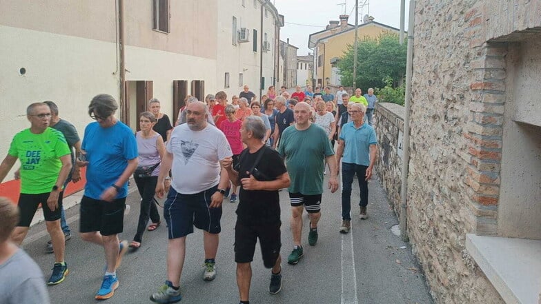 Luciano Fregonese (M, im grauen T-Shirt), Bürgermeister von Valdobbiadene, läuft mit einer Gruppe seiner Bürger durch die Straßen seiner Gemeinde.