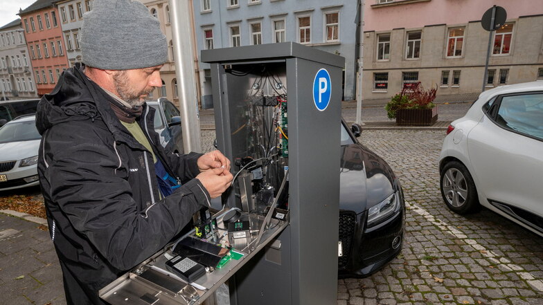 Ein Mitarbeiter der Thüringer Firma WSA Electronic bringt den neuen Parkautomaten an der Breiten Straße in Riesa in Gang. Noch ist das Parken dort aber kostenfrei.