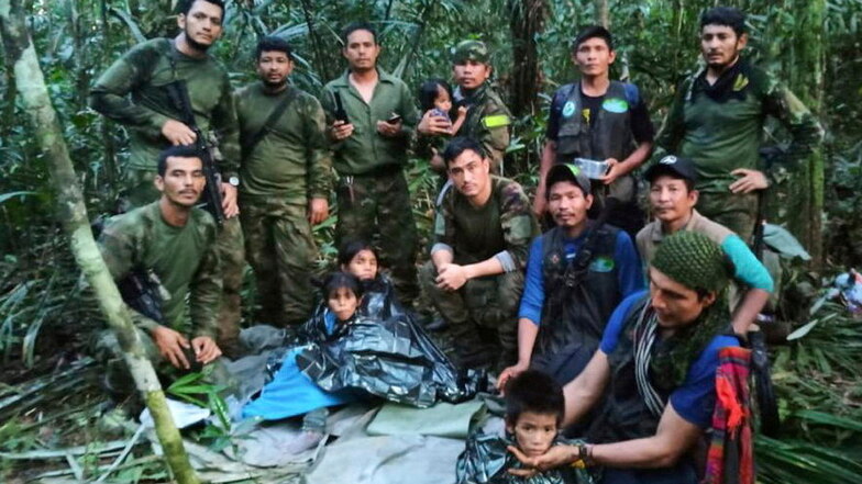Auf diesem von der Pressestelle der kolumbianischen Streitkräfte veröffentlichten Foto posieren Soldaten und indigene Männer für ein Foto mit den vier geretteten Geschwistern.