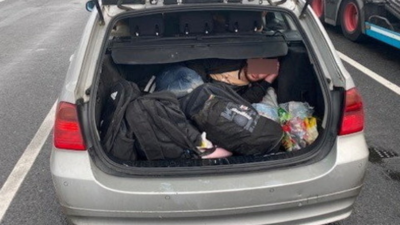 Ein Flüchtling verbirgt sich in einem Kofferraum. Ein Foto, das die Bundespolizei Ludwigsdorf zur Verfügung stellte.