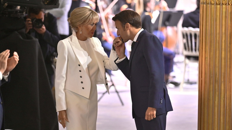 Emmanuel Macron (r) küsst die Hand seiner Frau, Brigitte Macron, First Lady von Frankreich.