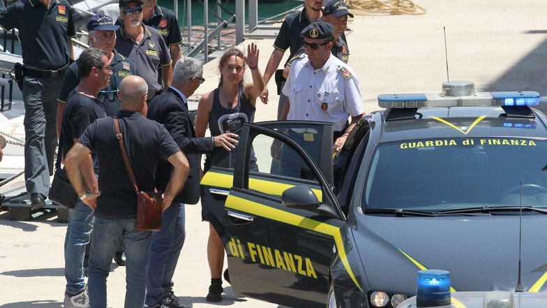 Carola Rackete (M), deutsche Kapitänin der Sea-Watch 3, steigt nach ihrer Ankunft im Hafen von Porto Empedocle in ein Polizeiauto.