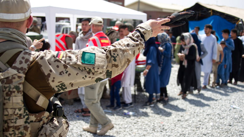 Kabul: Soldaten der Bundeswehr und Helfer verteilen eine Spende an Menschen, die auf eine Ausreisemöglichkeit warten.
