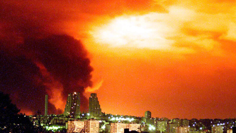 Schwarzer Rauch steigt in den vom Feuerschein rot erleuchteten Himmel über Belgrad, nachdem Nato-Bomben im April 1999 eine Raffinerie und eine Stickstoff-Fabrik nördlich der jugoslawischen Hauptstadt getroffen hatten.