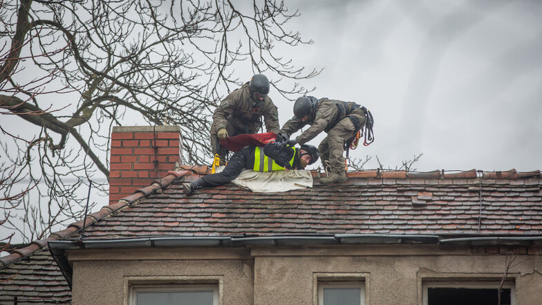 Polizisten des Spezialeinsatzkommandos sichern einen Demonstranten auf dem Dach eines besetzten Hauses auf der Königsbrücker Straße am 22. Januar. Auch eine Angeklagte, die bislang schweigt, soll auf dem Dach gewesen sein.