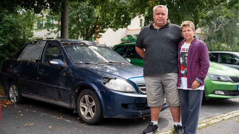 Alexander Lysechko und sein Sohn Danil vor ihrem zerstörten Auto in Weinhübel.