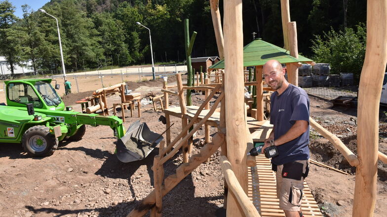 Ronny Kasper von der Jüterboger Holzgestaltungsfirma SIK montiert den Kletter- und Balancierparcours aus robustem Robinienholz auf dem neuen Mehrgenerationenplatz.