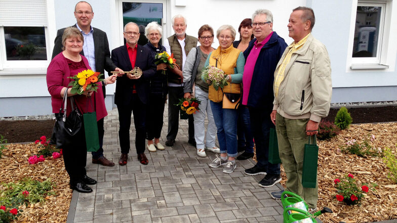 Wohnungsgesellschafts-Geschäftsführer Steffen Markgraf (hinten links) und Oberbürgermeister Stefan Skora (neben ihm) übergaben einen symbolischen Schlüssel an die Mieter.