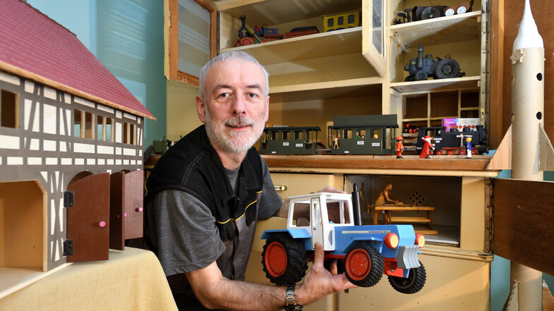 Mitarbeiter Jörg Schlegel zeigt in der Weihnachtsausstellung auf Schloss Burgk einen von ihm gebauten Traktor. Auch die Scheune und die Rakete stammen aus seiner Werkstatt.