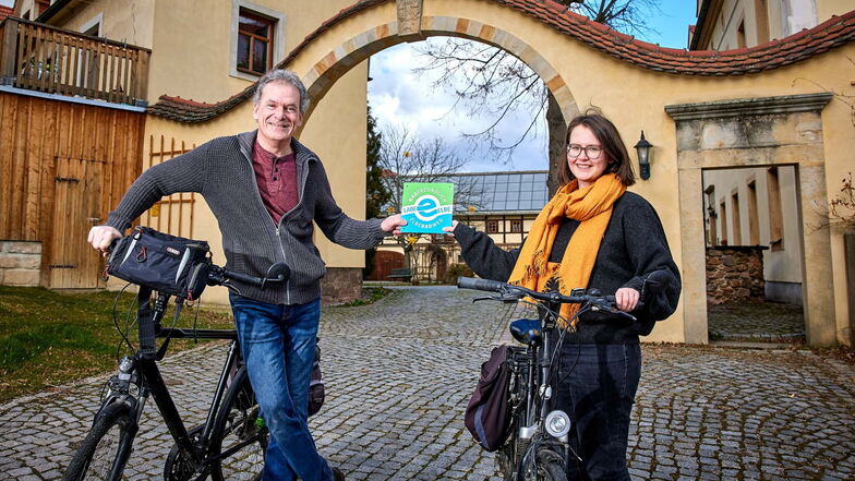 An dieser grün-blauen Plakette erkennen Radler die Unterkünfte: Elberadweg-Koordinatorin Heike Grunow übergibt sie an Hotelier Roland Taubinger vom Landhotel Gut Wildberg in Klipphausen.