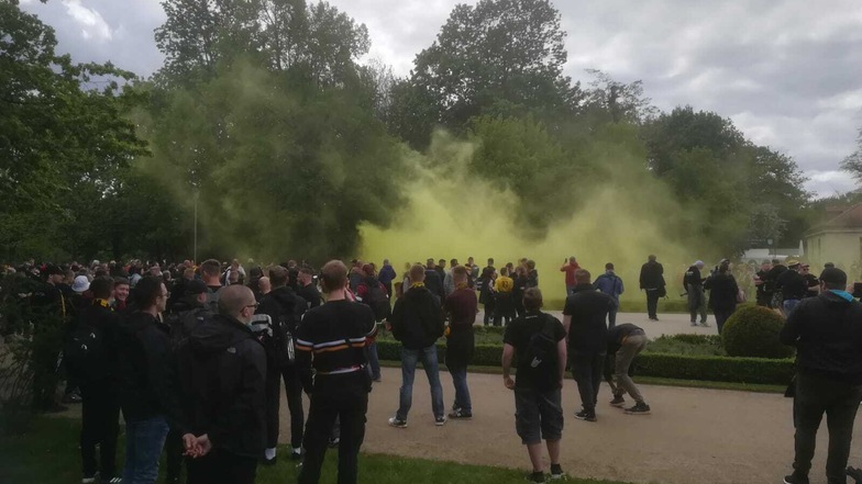 Am Eingang des Großen Gartens auf der Lennéstraße haben sich viele Dynamo-Fans versammelt, immer wieder wird auch Pyrotechnik gezündet.