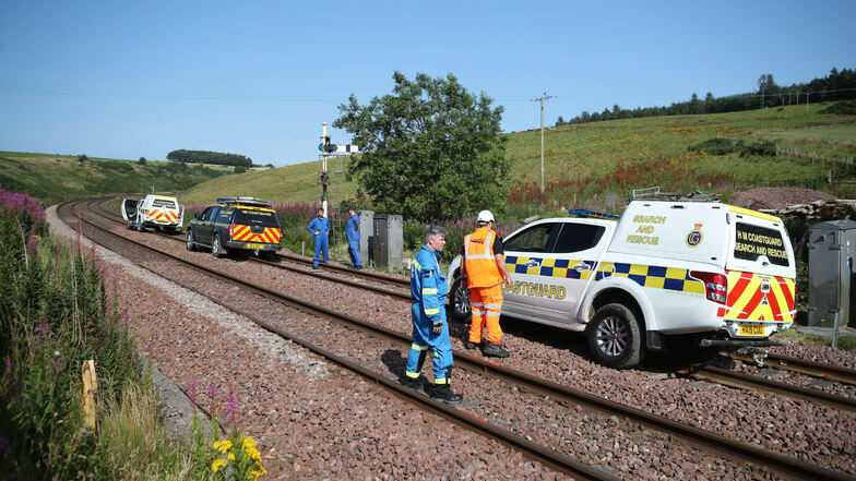 12.08.2020, Großbritannien, Stonehaven: Notfallfahrzeuge und Einsatzkräfte stehen auf Schienen. Bei einem Zugunglück in Schottland sind nach Medienberichten vermutlich drei Menschen ums Leben gekommen, darunter auch der Lokführer. Der Zug entgleiste a