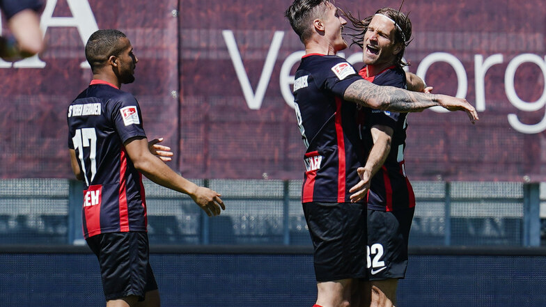 Hier jubeln die Spieler des SV Wehen Wiesbaden über den Führungstreffer gegen den VfB Stuttgart: Daniel Kofi Kyereh (l), Torschütze Manuel Schäffler (M.) und Stefan Aigner. Am Ende gewinnen sie mit 2:1.