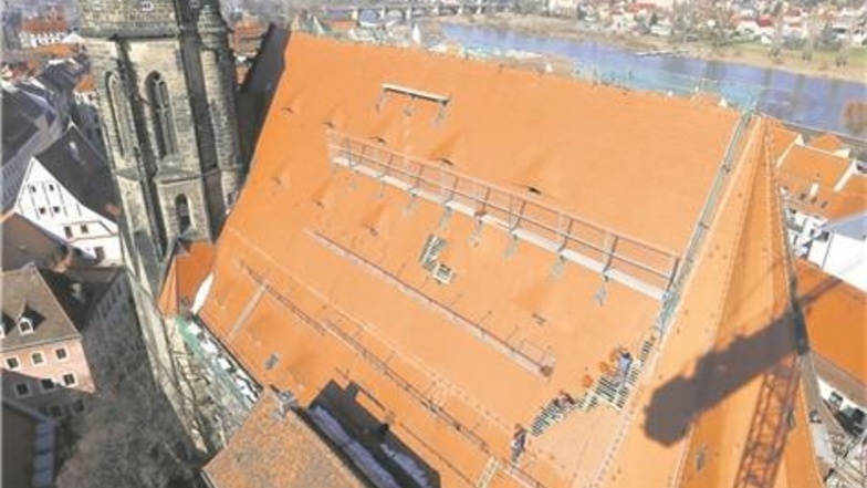 Verloren sehen die Dachdecker der Firma Quittel auf dem riesigen Marienkirchendach aus. Das Bild wurde vom Baukran aus (Schatten rechts) gemacht. Fotos: Marko Förster