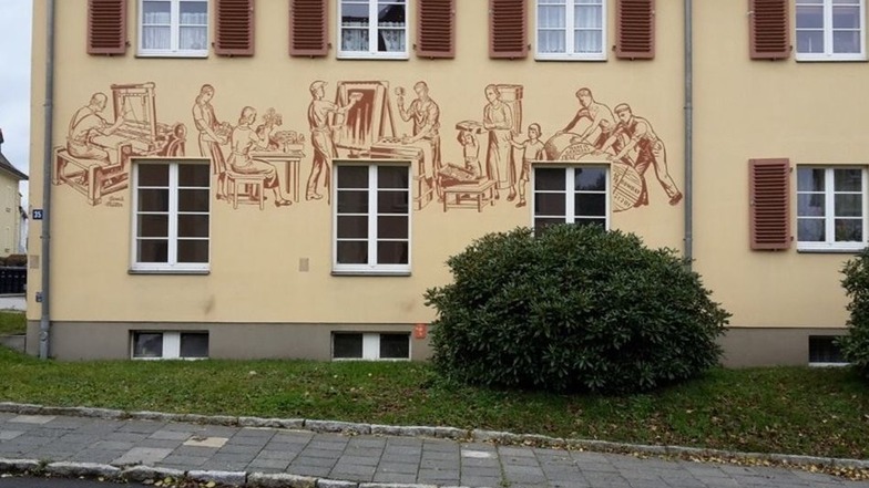 An der ehemaligen öffentlichen Badeanstalt zieren die Abbildungen von Berufen die Fassade.