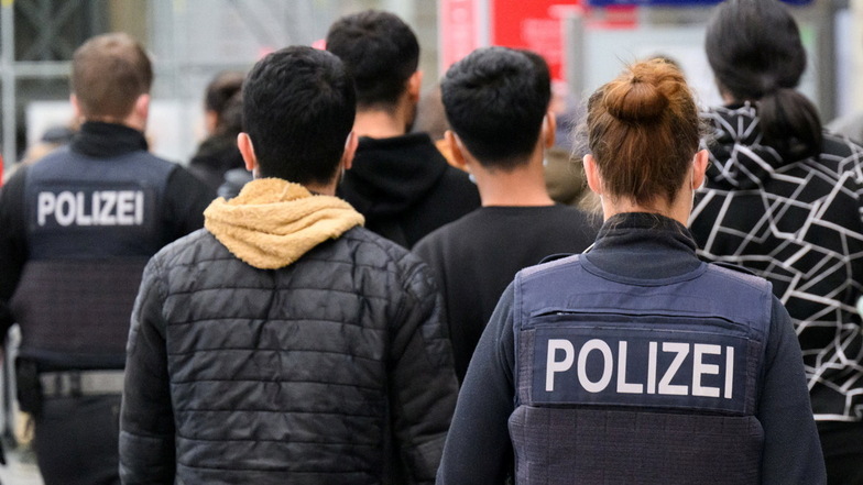 Polizisten der Bundespolizei führen auf dem Hauptbahnhof ankommende Flüchtlinge aus Syrien zum Bereich für die Registrierung.