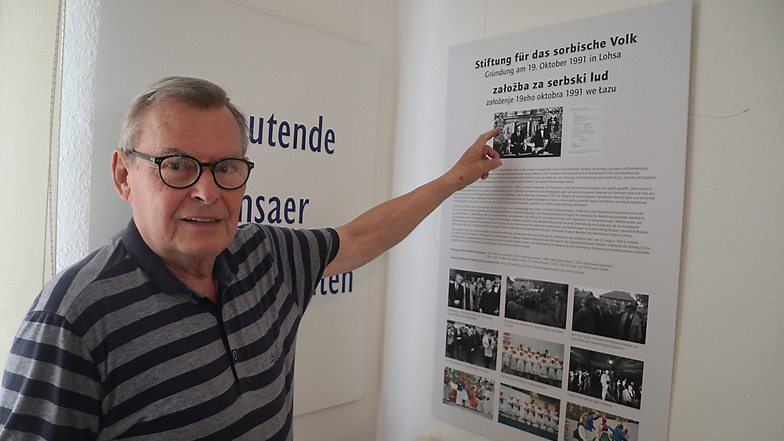 Reinhardt Schneider ist seit 2002 Vorsitzender des Fördervereins Begegnungsstätte Zejler-Smoler-Haus Lohsa e. V.. Vor Ort in der Dauerausstellung zeigt er auf die Erinnerungstafel zum Thema „30 Jahre Stiftung für das sorbische Volk“.