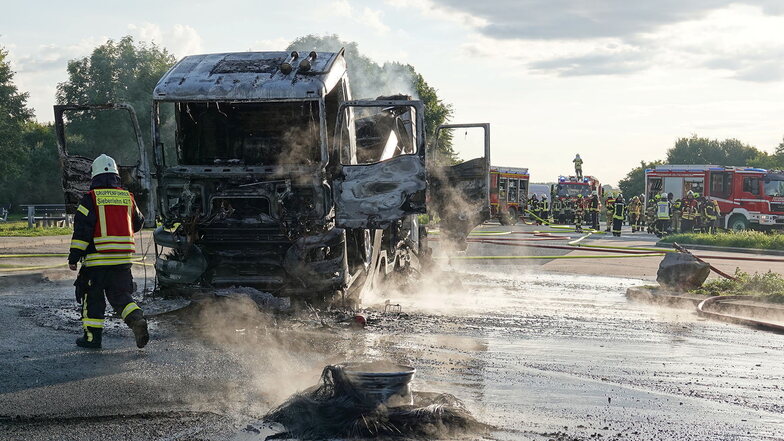 Der Auflieger mit dem anderen ausgebrannten Lkw. Im Vordergrund ein verbrannter Reifen.
