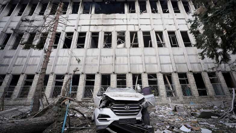 Ein zerstörtes Auto vor einem beschädigten Gebäude in Charkiw: Die Angriffe der Russen auf die Ukraine setzen sich fort.