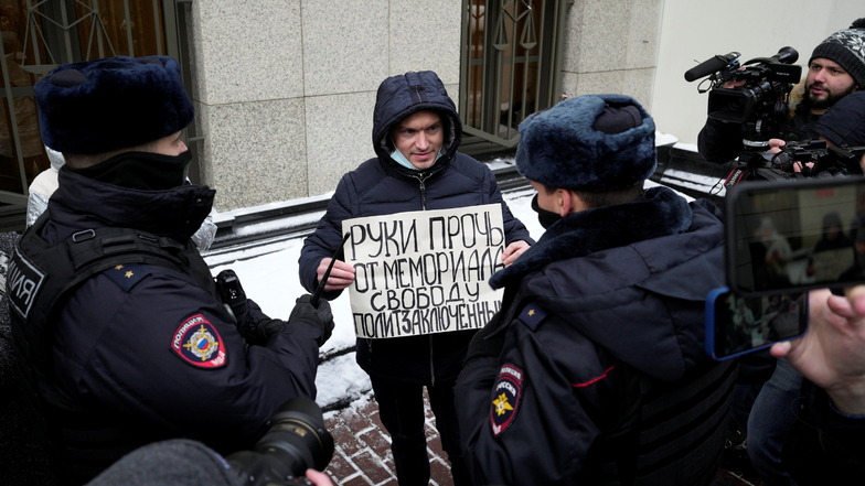 Polizeibeamte halten einen Demonstranten fest, der vor dem Obersten Gerichtshof der Russischen Föderation ein Plakat mit der Aufschrift "Hände weg von Memorial, Freiheit für politische Gefangene" hält.
