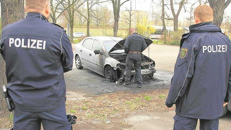 Auf dem Parkplatz zwischen Gret-Palucca-Straße und Wiener Straße wird eines der abgebrannten Fahrzeuge von der Polizei untersucht. Bis 20 Uhr waren Spezialisten an dem Tag im Einsatz.