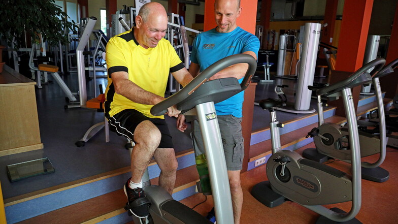 Der Nünchritzer Fitnesstrainer Hans-Jörg Schneese gibt Jens Walter auf dem Ausdauergerät Tipps.