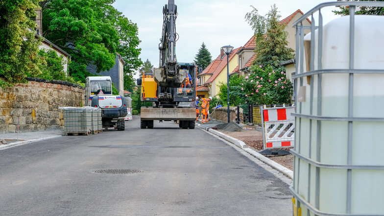 Zwischen Gerhart-Hauptmann-Straße und Hausbergweg ist der Asphalt schon auf der Fahrbahn. Die Bauarbeiter pflastern jetzt den neuen Gehweg.