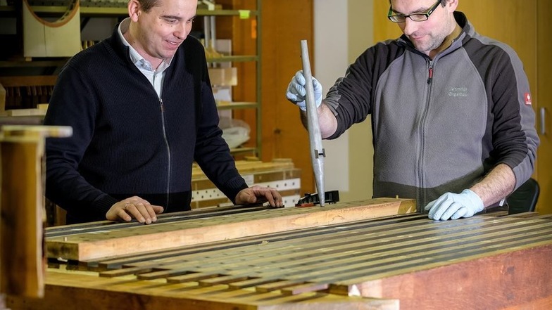 Geschäftsführer Ralf Jehmlich (l.) und Mitarbeiter Michael Kronesser an einer Windlade der Radeburger Orgel