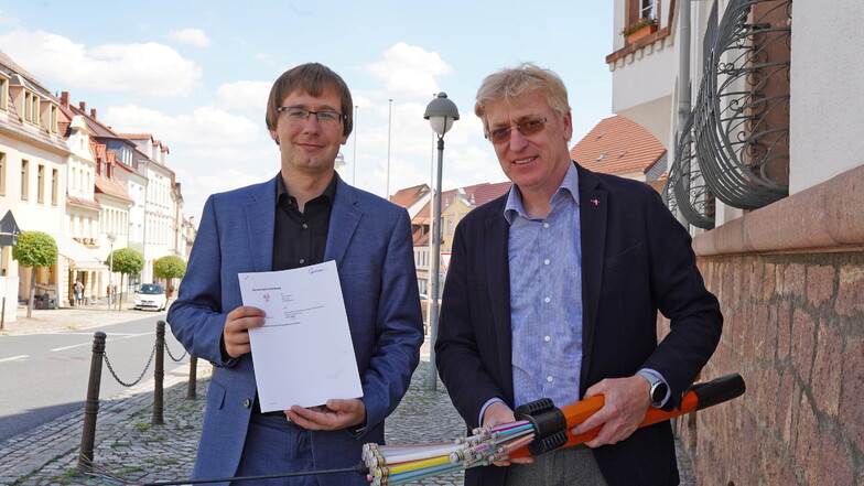 Nossens Bürgermeister Christian Bartusch und Telekom-Mitarbeiter Kai Gärtner haben einen Vertrag zur Zusammenarbeit bei der Abstimmung von Tiefbauarbeiten für das Glasfasernetz unterschrieben.