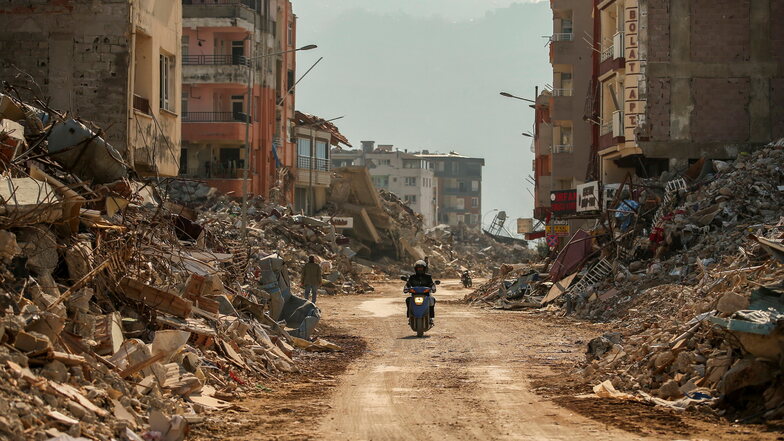 Ein Mann fährt auf einem Motorrad durch die Trümmer zerstörter Gebäude in der Südosttürkei. Dort gab es erneut ein Erdbeben der Stärke 5,5.