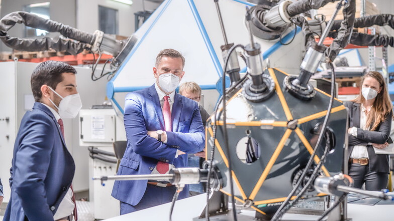 Sächsische Idee für den Mars: In der Hartmannsdorfer Werkhalle der Firma Metron zeigt Vertriebsexperte Hugo Albero Rojas (links) dem Wirtschaftsminister Martin Dulig einen 3D-Drucker, der an jedem Ort Ersatzteile aus Kunststoff herstellen könnte.