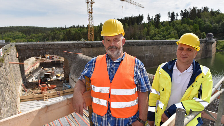 Der Projektverantwortliche bei der Landestalsperrenverwaltung Bernd Findeisen (li.) und der Abteilungsleiter Bau Stephan Leonhardt stehen vor der Baustelle für den erweiterten Hochwasserüberlauf.