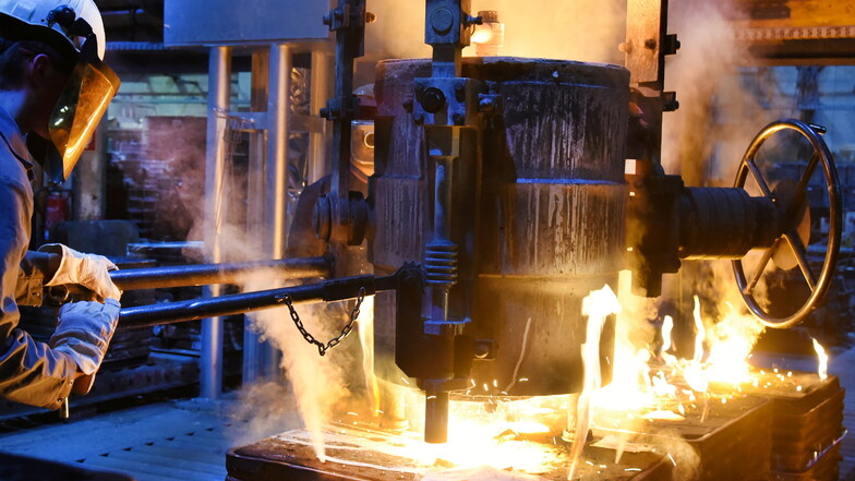 Im Schmelzbetrieb einer Gießerei bei Leipzig füllt ein Mechaniker geschmolzenes Metall in vorgefertigte Formen. Die Branche leidet unter hohen Stromkosten.