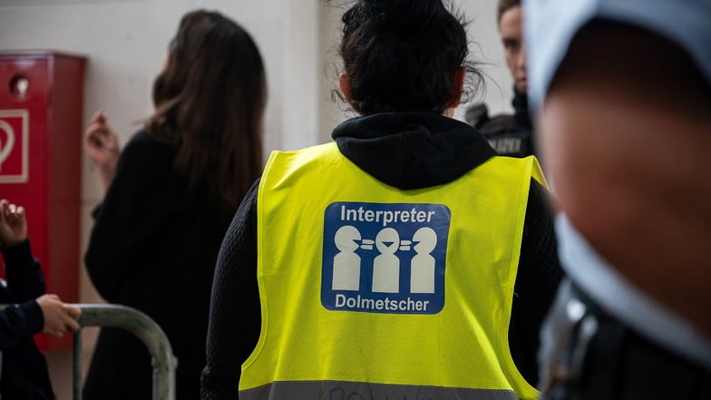 Eine Dolmetscherin spricht mit Geflüchteten in der Erstaufnahme-Station für Geflüchtete auf dem Gelände der Bundespolizei in Ludwigsdorf.