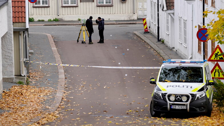 Zwei Polizisten ermitteln in der Nähe des Tatorts nach einer Gewalttat in der norwegischen Kleinstadt Kongsberg.