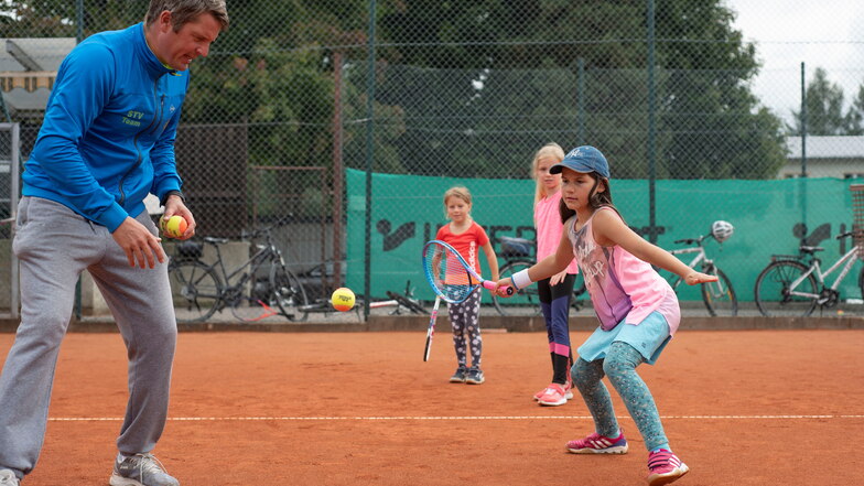 Von den Profis lernen: Im Pulsnitzer Tennis-Camp zeigt Sachsentrainer Volker Schmidt Feline (vorn), wie sie am besten den Ball zu nehmen hat. Lena (hinten) und Henriette schauen zu.