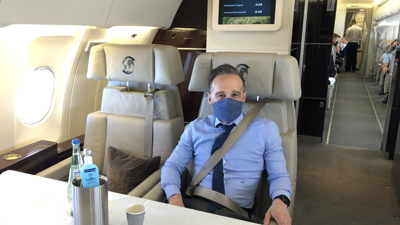 Heiko Maas (SPD), Außenminister, sitzt mit Mund- und Nasenschutz in einem Flugzeug der Luftwaffe.